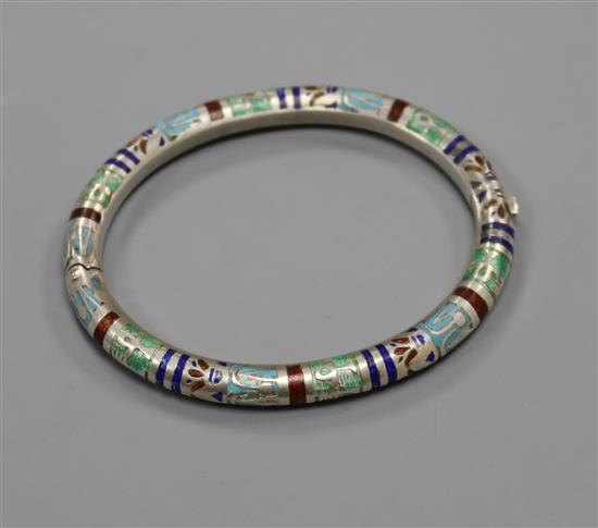An Egyptianesque white metal and enamel hinged bangle.